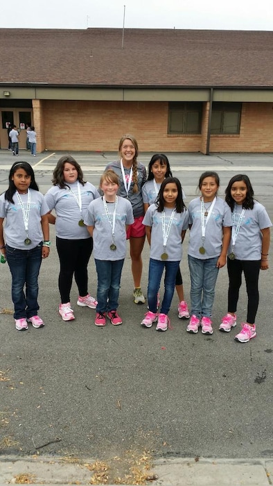 Meryl Call of the Salt Lake City Track Club poses with the fifth-grade girls she coached in the annual Making Strides running program that introduces underserved youth to the sport.