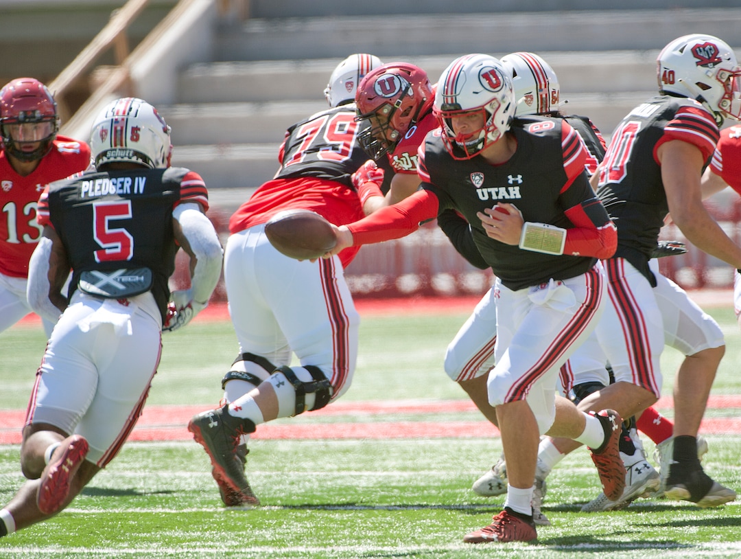 (Ed Kosmicki | Special to The Tribune) Black team QB Peter Costelli hands off the ball to running back T J Pledger during the annual spring football game at the University of Utah, 17 April 2021.
