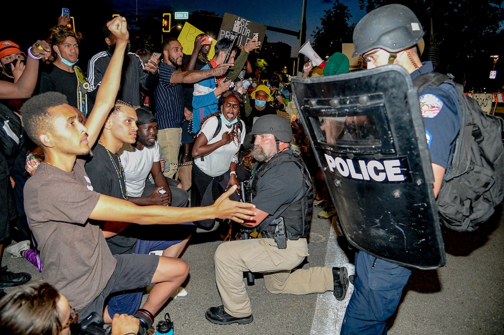 (Francisco Kjolseth | The Salt Lake Tribune) An officer takes a knee with a group of demonstrators protesting against police brutality in downtown Salt Lake City on Wednesday, June 3, 2020.