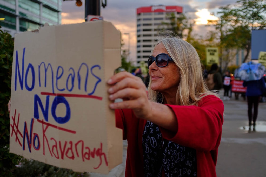 (Trent Nelson | The Salt Lake Tribune)
Jane Cunningham Otis holds a sign out to passing cars at a protest against the nomination of Brett Kavanaugh in front of the Wallace F. Bennett Federal Building in Salt Lake City, Thursday Oct. 4, 2018.