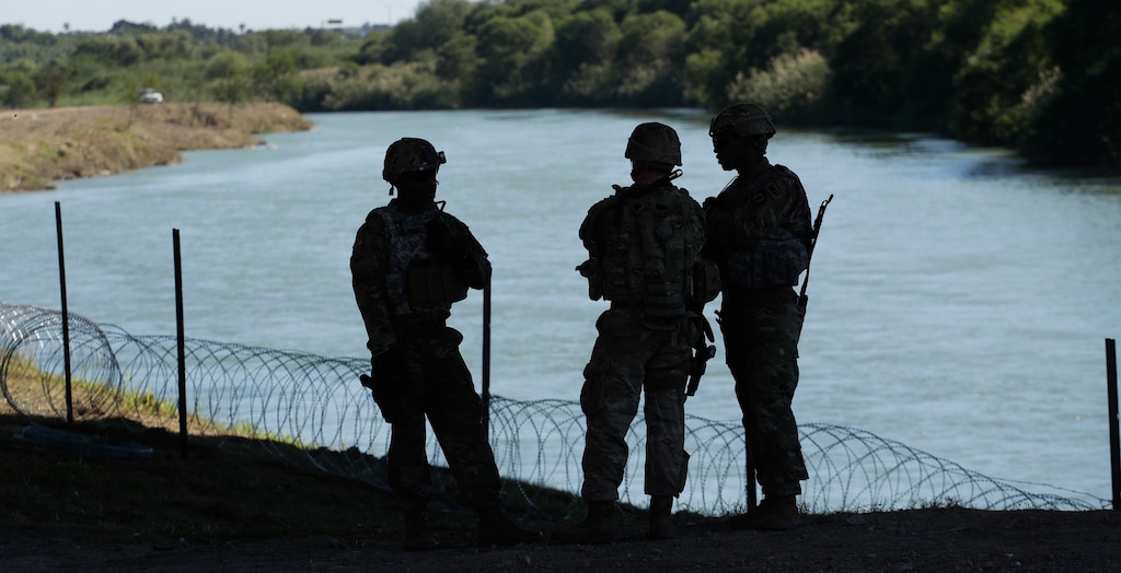 Members of the U.S. military install multiple tiers of concertina wire along the banks of the Rio Grande near the Juarez-Lincoln Bridge at the U.S.-Mexico border, Friday, Nov. 16, 2018, in Laredo, Texas. (AP Photo/Eric Gay)