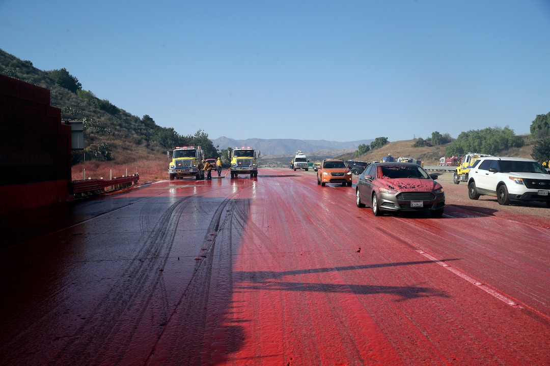 (Marcio Jose Sanchez | AP)  Highway 23 is covered in fire retardant after an air tanker drop as the Easy Fire threatened to jump the highway Wednesday, Oct. 30, 2019, in Simi Valley, Calif.
