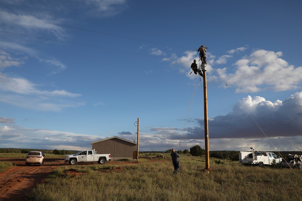 (Jake Bacon | AP file photo) Utility workers prepare a power pole to connect a home in Kaibeto on the Navajo Nation to the electric grid in May 2019.