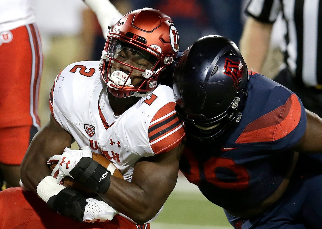 Utah running back Zack Moss (2) is tackled by Arizona defensive lineman Dereck Boles during the first half of an NCAA college football game, Friday, Sept. 22, 2017, in Tucson, Ariz. (AP Photo/Rick Scuteri)