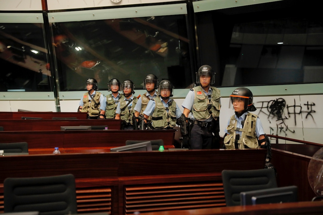 (Kin Cheung | AP Photo) Police officers with protective gear retake the meeting hall of the Legislative Council in Hong Kong, during the early hours of Tuesday, July 2, 2019. Hundreds of protesters in Hong Kong swarmed into the legislature's main building Monday night, tearing down portraits of legislative leaders and spray-painting pro-democracy slogans on the walls of the main chamber as frustration over a lack of response from the administration to opposition demands boiled over.