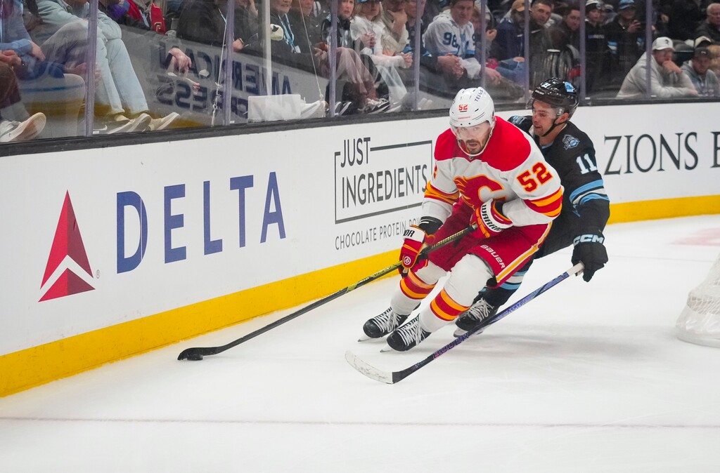 (Bethany Baker  |  The Salt Lake Tribune) Calgary Flames defenseman MacKenzie Weegar (52) keeps the puck away from Utah Hockey Club right wing Dylan Guenther (11) during the game at the Delta Center in Salt Lake City on Tuesday, April 1, 2025.