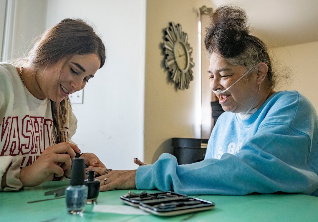 (Rick Egan | The Salt Lake Tribune) Madii Lewis paints the nails of her mom, Tina, black for Halloween at their home in Idaho Falls, Idaho on Tina's first full day home from the hospital, on Thursday, Sept. 23, 2021. Lewis spent most of the past 6 months in hospitals sick with COVID-19.