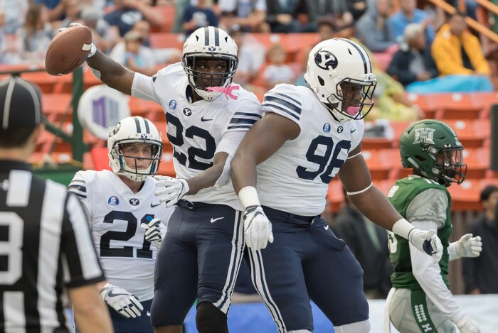 BYU running back Squally Canada (22) celebrates a touchdown with teammate offensive lineman JJ Nwigwe (96) as wide receiver Talon Shumway (21) looks on in the second quarter of an NCAA college football game against Hawaii, Saturday, Nov. 25, 2017, in Honolulu. (AP Photo/Eugene Tanner)