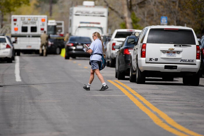 (Trent Nelson | The Salt Lake Tribune)  
A mail carrier continues her route along 1100 East despite law enforcement working an incident where a man barricaded himself in a house on Princeton Avenue in Salt Lake City, Wednesday April 18, 2018.