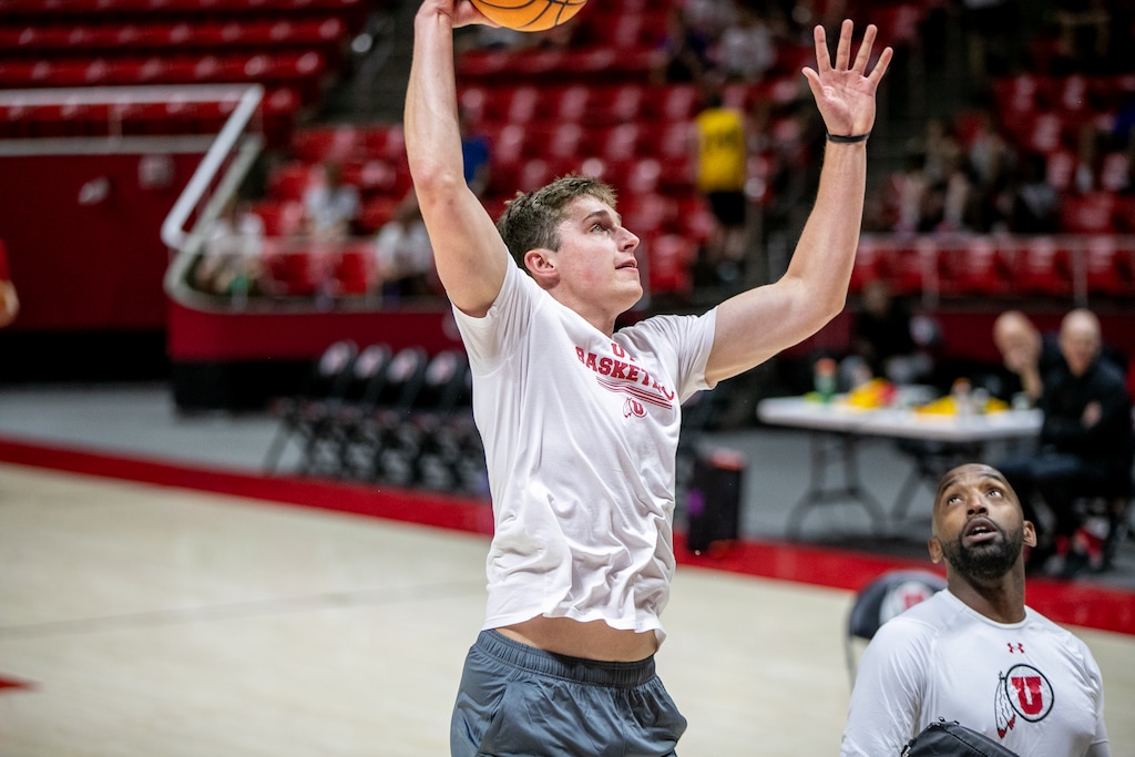 (Utah Athletics) University of Utah forward Ben Carlson goes up for a shot during a recent practice as assistant coach Tim Morris looks on.