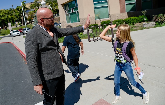 (Francisco Kjolseth | The Salt Lake Tribune) Washington Elementary school principal John Kelly, gets a high five from Ella Mortensen following their first day back at school on Monday, Aug. 19, 2019.