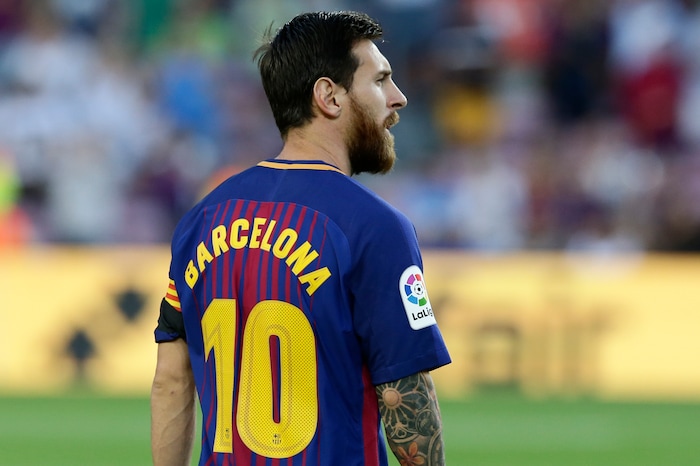 Barcelona's Lionel Messi wears a shirt with 'Barcelona' on his back instead of his name as did all Barcelona players to pay homage to the van attack victims before a La Liga soccer match between Barcelona and Betis at the Camp Nou stadium in Barcelona, Spain, Sunday, Aug. 20, 2017. Security was stepped up for the match after a terror attack that killed 14 people and wounded over 120 in Barcelona and police put up scores of roadblocks across northeast Spain on Sunday in hopes of capturing a fugitive suspect at large following the vehicle attack.(AP Photo/Manu Fernandez)