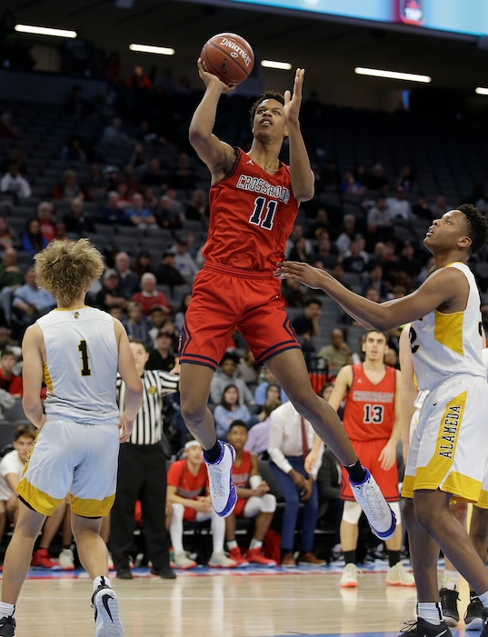 FILE - In this March 23, 2018, file photo, Crossroads forward Shareef O'Neal, center, goes to the basket against Alameda center Kinglsey Obiorah, right, during the second half of the Division II boys high school championship game, in Sacramento, Calif. The son of retired NBA great Shaquille O'Neal signed a grant-in-aid to attend UCLA this fall. He will enroll in summer school this month. (AP Photo/Rich Pedroncelli, File)