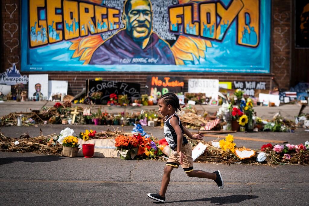 (Leila Navidi | Star Tribune via AP) In this June 25, 2020 photo, Carter Sims, 3, of Pine Island, Minn., runs past a mural at the George Floyd memorial outside Cup Foods in Minneapolis. A stretch of a Minneapolis street that includes the place where Floyd was killed will soon be named in his honor. The City Council approved the naming Friday, Sept. 18, and Mayor Jacob Frey’s office said he would likely sign off on it as well.