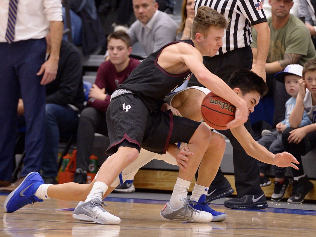 (Leah Hogsten  |  The Salt Lake Tribune) Lone Peak's Steven Ashworth hits the deck after a foul from Pleasant Grove's Kawika Akina.  Lone Peak High School boys' basketball team defeated Pleasant Grove High School 65-61 during their game Friday, January 26, 2018 in Pleasant Grove. 