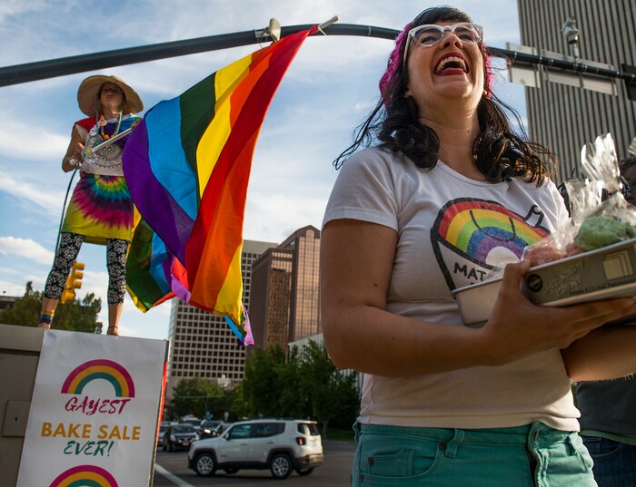 (Leah Hogsten  |  The Salt Lake Tribune) l-r Shell Danis dances at the corner of State and North Temple as Kate Kelly hands out cookies Monday evening. Supporters and members of theLGBTQIA+ community held the Gayest Bake Sale Ever, September 18th, 2017 at City Creek Park  in response to the LDS Church and Utah legislators who support the Colorado baker who refused to make a cake for a same-sex couple's wedding. All proceeds of the bake sale will go to the Utah Pride Center, specifically to fund the Pride Center's LGBTQ+ Youth Survivors of Suicide Support Group.