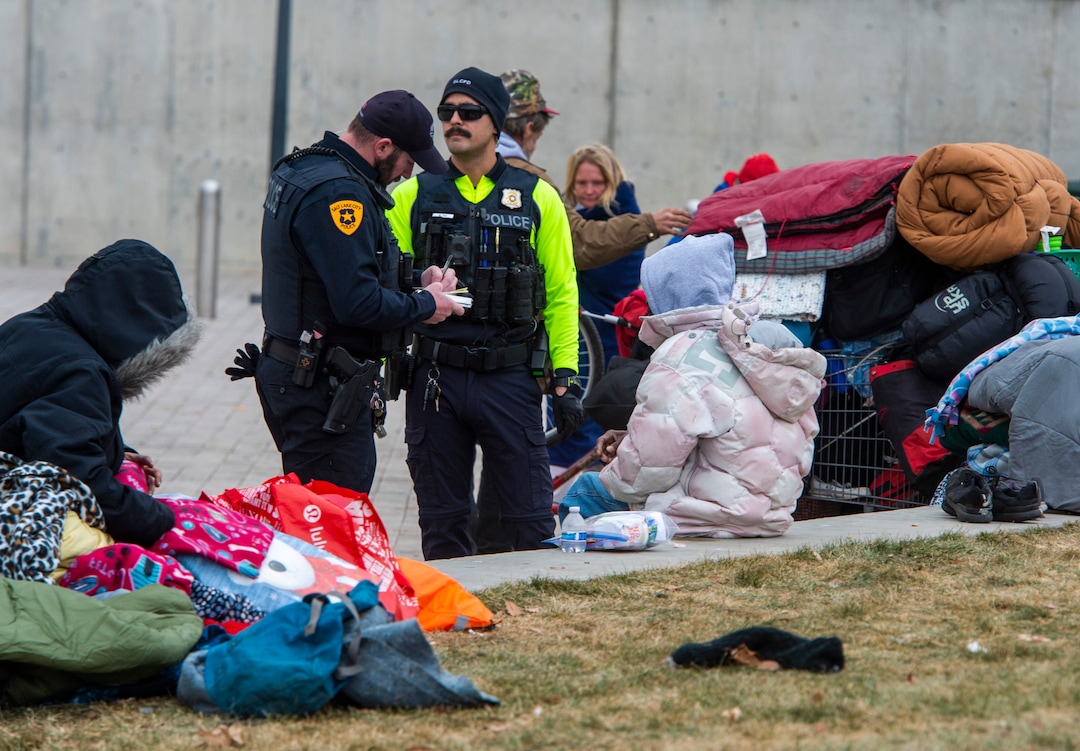 (Rick Egan | The Salt Lake Tribune) Salt Lake City Police speak to people experiencing homelessness near the Salt Lake City Library, Monday, Dec. 23, 2019.