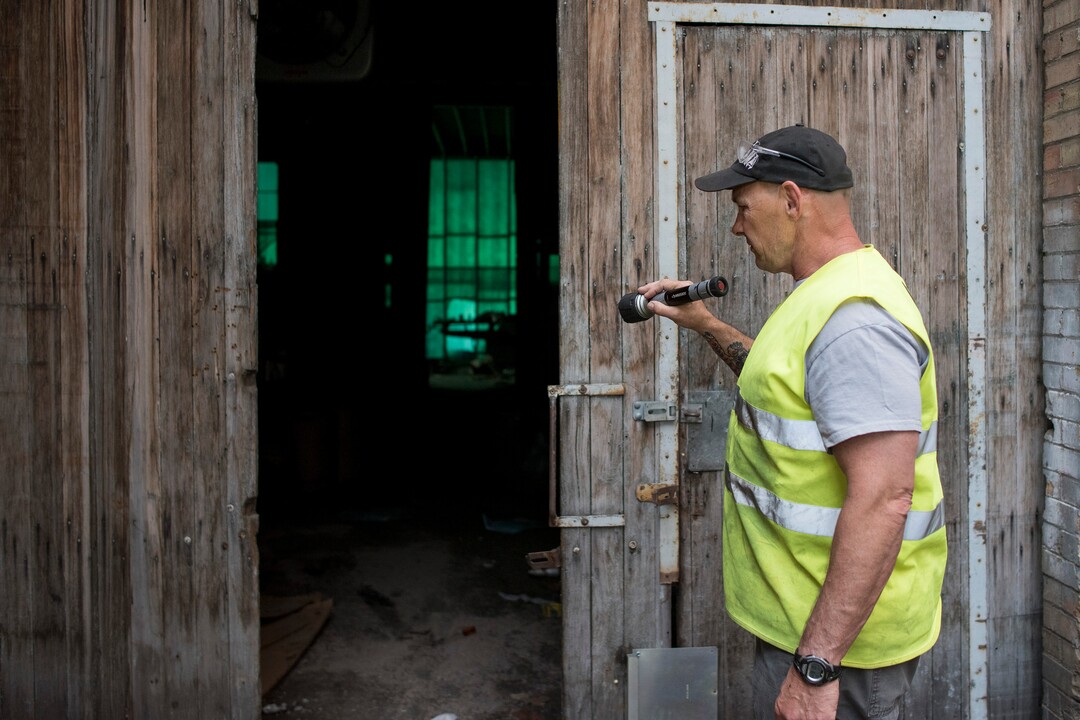 (Briana Scroggins  |  The Utah Investigative Journalism Project) EPA On-scene Coordinator Paul Peronard shines a light into one of the entrances to the Swift building in Ogden on Thursday, May 16, 2019. The EPA started site clean up on April 1 and plan to finish by August 2019.