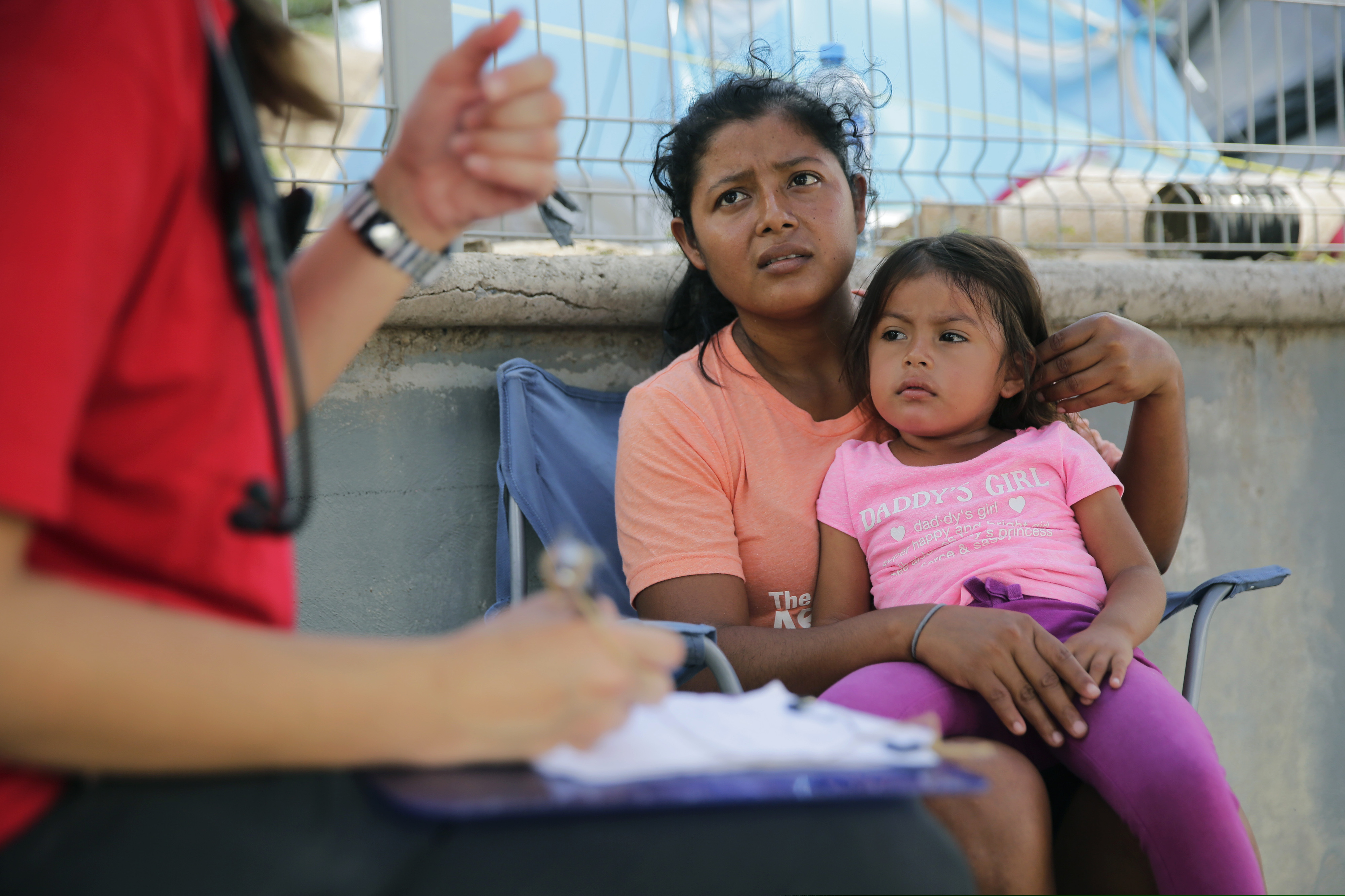 In this Tuesday, Nov. 5, 2019, photo, migrants see a health care worker as they receive medical care at sidewalk clinic at refugee camp in Matamoros, Mexico. The few doctors and nurses working in the camp are treating people including pregnant women and children with respiratory problems, skin conditions, diarrhea, and other diseases that can be linked to the camp’s unsanitary conditions. (AP Photo/Eric Gay)