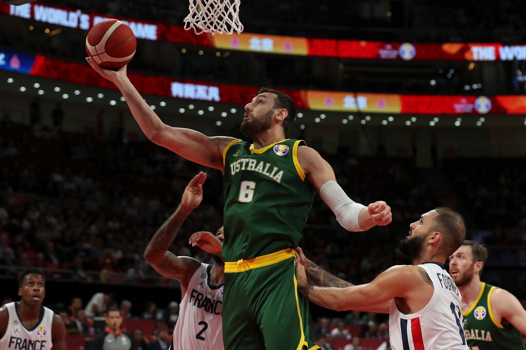 (Ng Han Guan | AP file photo) Andrew Bogut of Australia puts up a shot over Amath M'Baye, left, and Evan Fournier of France on Sept. 15, 2019, during their third placing match for the FIBA Basketball World Cup at the Cadillac Arena in Beijing. The 35-year-old Bogut, a 2005 No. 1 draft pick out of the University of Utah by Milwaukee and who won an NBA championship with the Golden State Warriors in 2015, was planning to retire after playing for Australia at the Tokyo Games in three months. Those games have been delayed until July 2021.