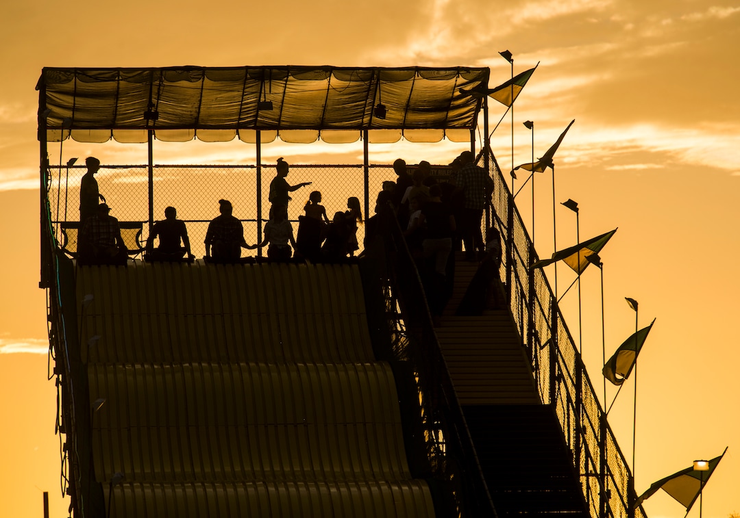 (Rick Egan  |  The Salt Lake Tribune)   Riders prepare to slide down the Big Yellow Slide, as the sun sets, at the Utah State Fair, on a busy Monday,  Sept. 10, 2018.