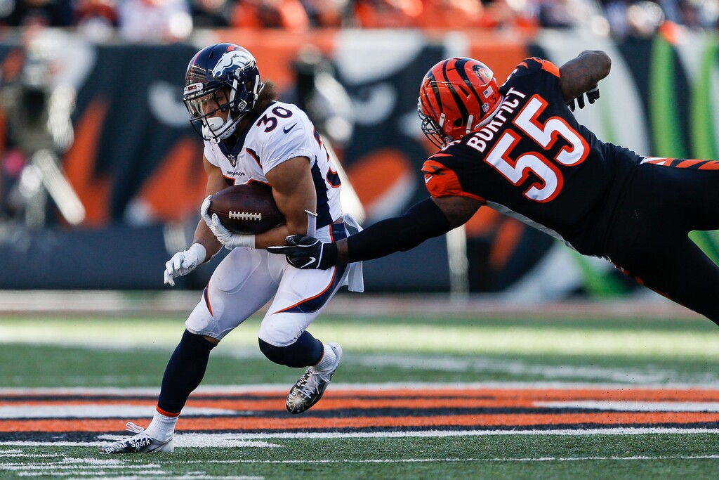 Denver Broncos running back Phillip Lindsay (30) breaks away from Cincinnati Bengals outside linebacker Vontaze Burfict (55) in the first half of an NFL football game, Sunday, Dec. 2, 2018, in Cincinnati. (AP Photo/Gary Landers)