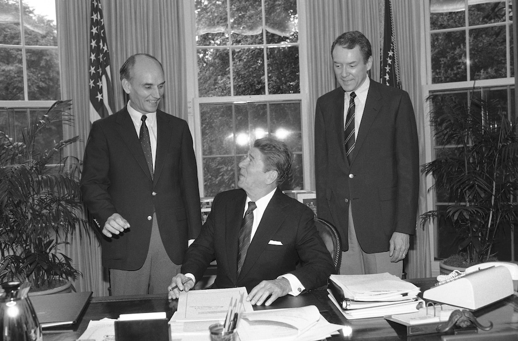 FILE - In this Sept. 28, 1984, file photo, U.S. President Ronald Reagan signs S. 2155, the Utah Wilderness Act of 1984 in the White House Oval Office in Washington as Utah Senator Orrin Hatch looks on. Hatch is ending his tenure as the longest-serving Republican senator in history, Thursday, Jan. 3, 2019, capping a unique career that positioned him as one of the most prominent conservative voices in the United States.   (AP Photo/Barry Thumma, File)