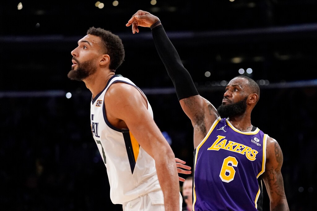 Los Angeles Lakers forward LeBron James, right, watches along with Utah Jazz center Rudy Gobert as his three-point shot goes in during the second half of an NBA basketball game Wednesday, Feb. 16, 2022, in Los Angeles. The Lakers won 106-101. (AP Photo/Mark J. Terrill)