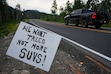(Bethany Baker  |  The Salt Lake Tribune) A truck drives past a sign, seen here along South Guardsman Pass Road near Brighton on Tuesday, July 15, 2025, that opposes the requested 593-space parking lot for Solitude Mountain Resort that would be in an aspen grove across SR-190 from the ski area's main village. The lot would require steep retaining walls and the removal of hundreds of trees, could also damage Salt Lake City's watershed, further snarl traffic in the canyon and be a visual blight. Solitude officials say it would help move parking off the roadside.