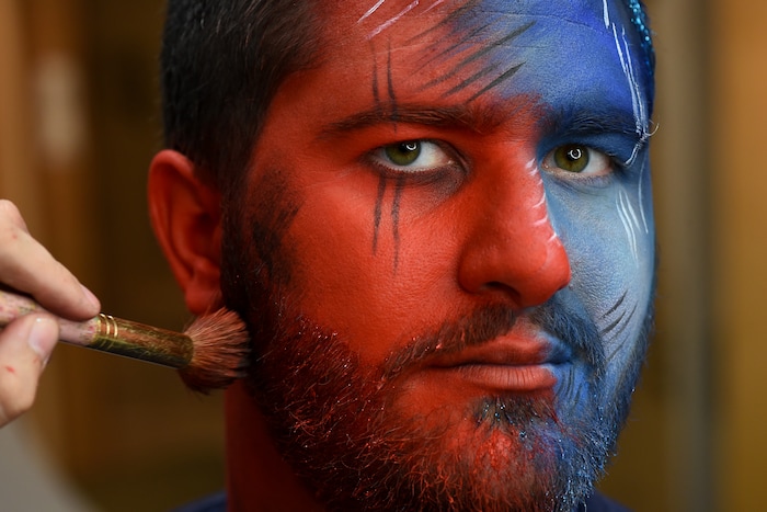 (Francisco Kjolseth | The Salt Lake Tribune) BYU and Utah fan alike Brad Klekas of South Jordan shows his mutual admiration by stepping into the Tribune studio to get both colors in anticipation of the upcoming match up between the two rival teams on Saturday.