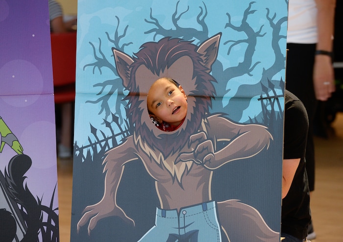 (Francisco Kjolseth  |  The Salt Lake Tribune)  Jonathan Clark, 6, gets a little help from his dad, Jeremy, as he peeks through a werewolf cutout as volunteers and staff at Shriners Hospital for Children in Salt Lake transform his wheelchair into a monster truck for Halloween, Wednesday, Oct.  17, 2018.