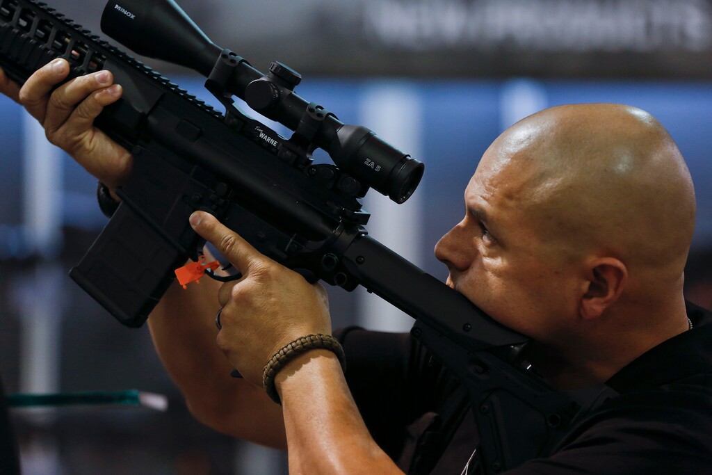 FILE - This Jan. 14, 2014 file photo shows Michael Wright, of the Montgomery County Sheriff's office in Conroe, Texas, looking through the sight of a rifle at the Shooting Hunting and Outdoor Trade Show in Las Vegas. Fresh off a victory in Washington state, a leading gun control group, Everytown for Gun Safety, has targeted Oregon as the next prize in a campaign to require all gun sales go through background checks to keep them from criminals, the mentally ill and domestic abusers. (AP Photo/Julie Jacobson)