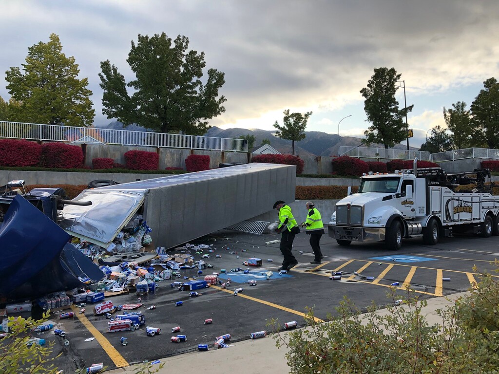 (Courtesy of FOX 13 News) A semi-trailer carrying a haul of Bud Light beer overturned in a parking lot of an LDS Church near 11300 South and 1300 East on Thursday, Oct. 10, 2019.