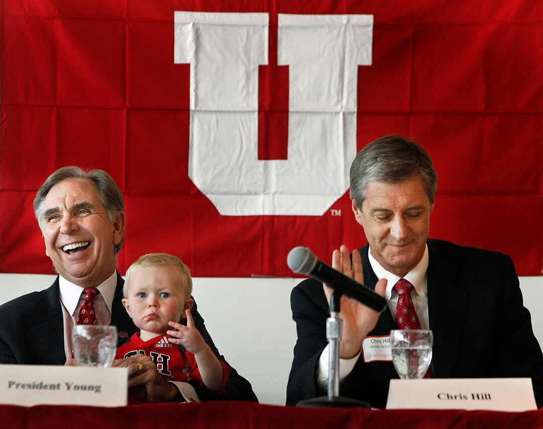 (Scott Sommerdorf  |  Tribune File Photo)  University of Utah President Michael Young (left) holds his grandson Bryce Owen (1 and a half years), in his lap as he spoke about the University's acceptance of the Pac-10's invitation to join the conference on Tuesday June 17, 2010. At right is Athletic Director Dr. Chris Hill.