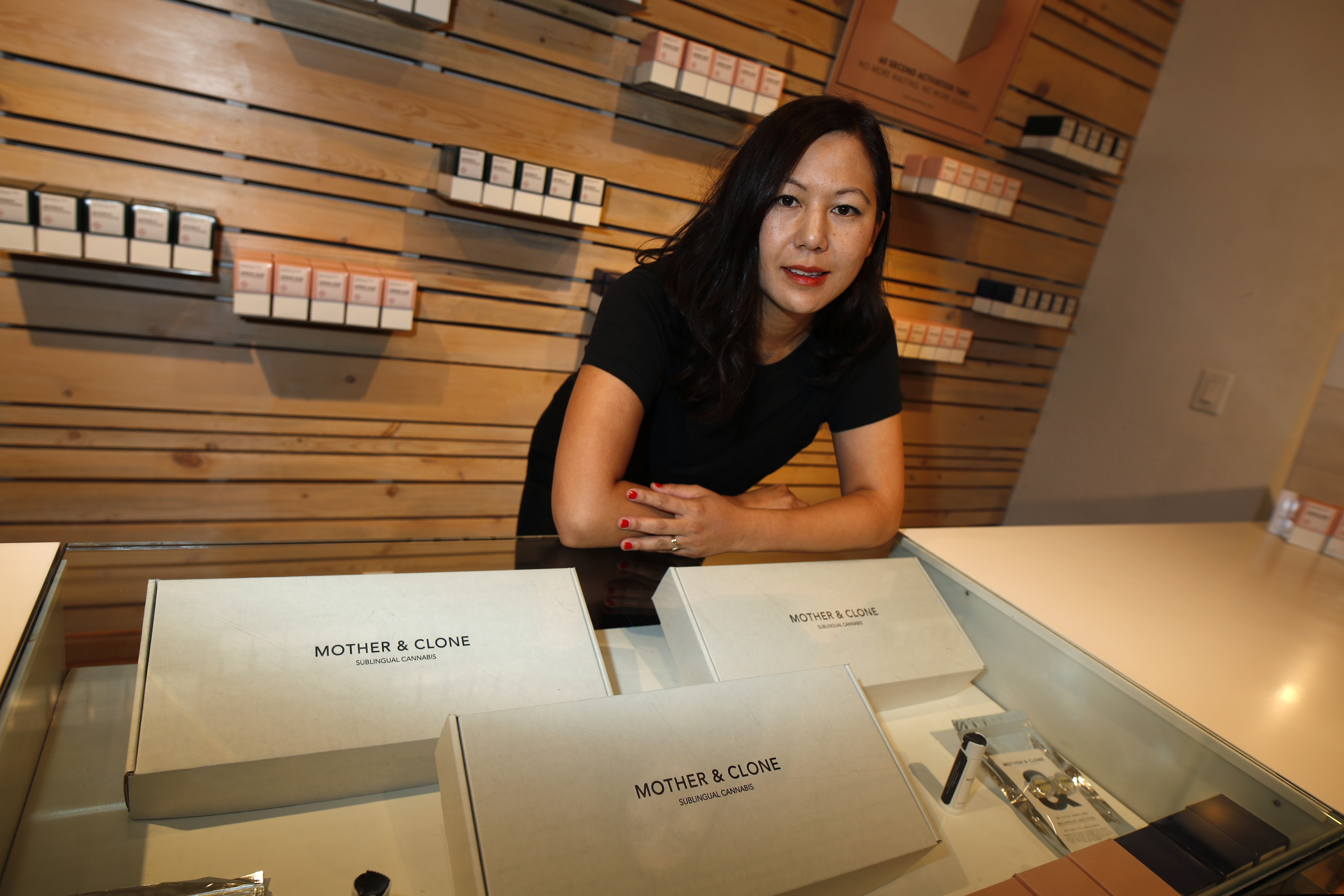 (David Zalubowski | AP) Leslie Siu poses for a portrait next to her cannabis spray products geared toward women on display in Groundswell dispensary in east Denver on Friday, July 26, 2019. Pregnancy started out rough for her. Morning sickness and migraines had her reeling and barely able to function at a demanding New York marketing job, so like rising numbers of U.S. mothers-to-be, she turned to marijuana. “l was finally able to get out from under my work desk,” said Siu, who later started her own pot company and says her daughter, now 4, is thriving.