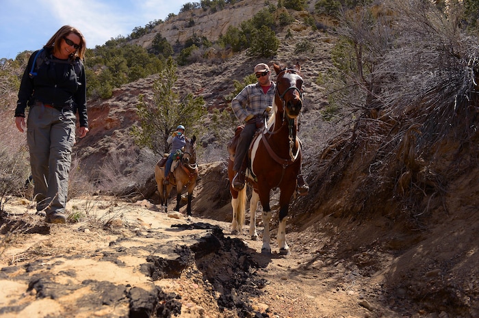 (Leah Hogsten | Tribune file photo) From left, Escalante residents Jana Richman, Carol Kracht and Nate Waggoner hike the Little Valley Wash, Saturday, March 29, 2014 to inspect the washÕs sandstone walls and beds covered with oil that was found by a hiker earlier in the week. The group likened the thick oil bed to asphalt pavement. The oil is from the Upper Valley oil field, operated by Citation Oil and Gas Corporation.