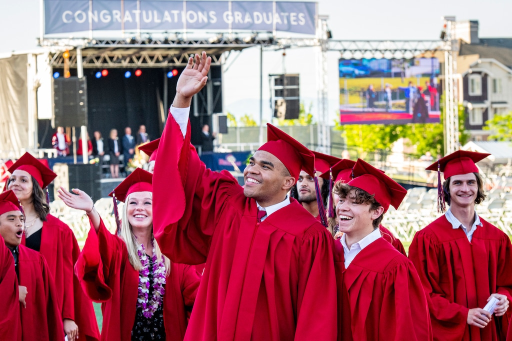 (Isaac Hale | Special to The Tribune) Graduates wave to family and friends while their processional moves onto the field during Herriman High School’s graduation ceremony held Thursday, June 3, 2021.