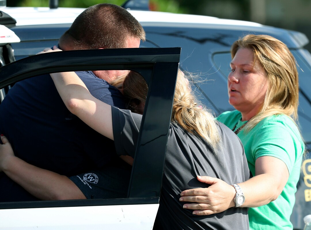 A Santa Fe Police officer consoles others after a shooting at Santa Fe High School in Santa Fe, Texas on Friday, May 18, 2018. (Jennifer Reynolds /The Galveston County Daily News via AP)