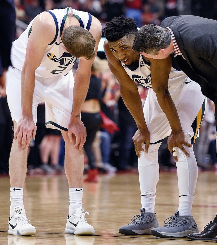 Utah Jazz guard Donovan Mitchell, center, is check on by Joe Ingles, left, and an assistant coach after sustaining an injury during the second half in Game 5 of an NBA basketball second-round playoff series against the Houston Rockets, Tuesday, May 8, 2018, in Houston. Mitchell left the game and did not return. (AP Photo/Eric Christian Smith)