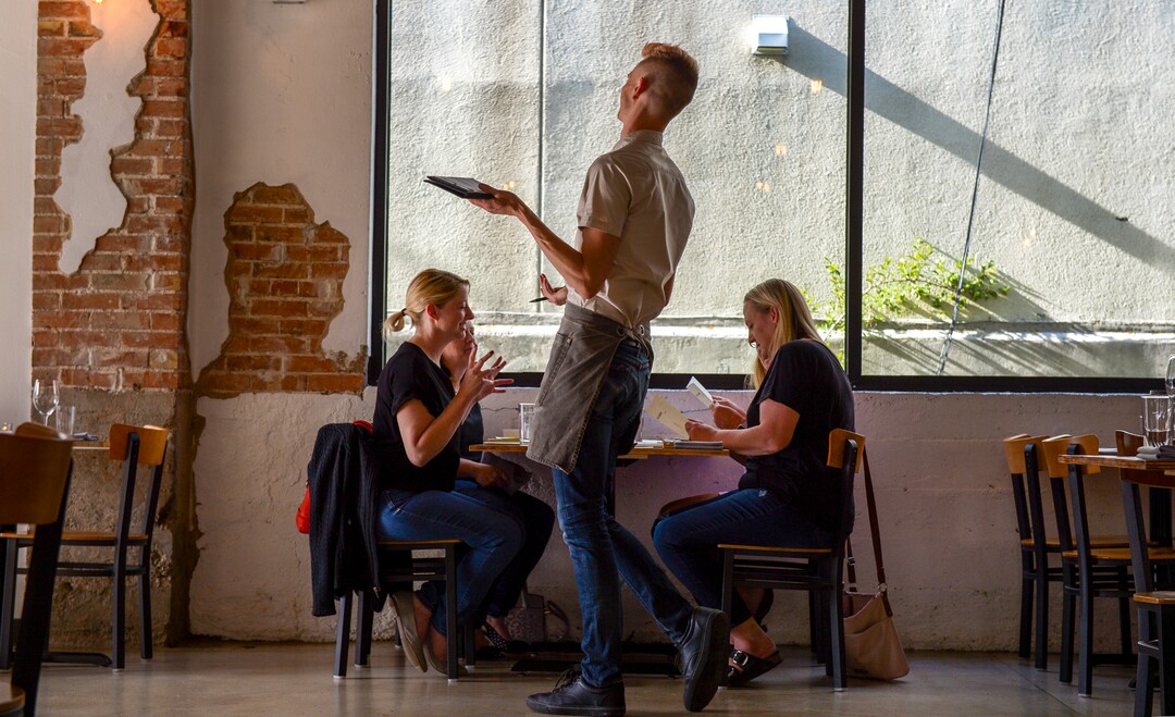 Leah Hogsten  |  The Salt Lake Tribune SLC Eatery server Justin Swensen shares a laugh with a diner Friday, May 3 2019. The restaurantÕs regular menu and the cart offerings include globally inspired flavors of Latin America, the Mediterranean and Asia.