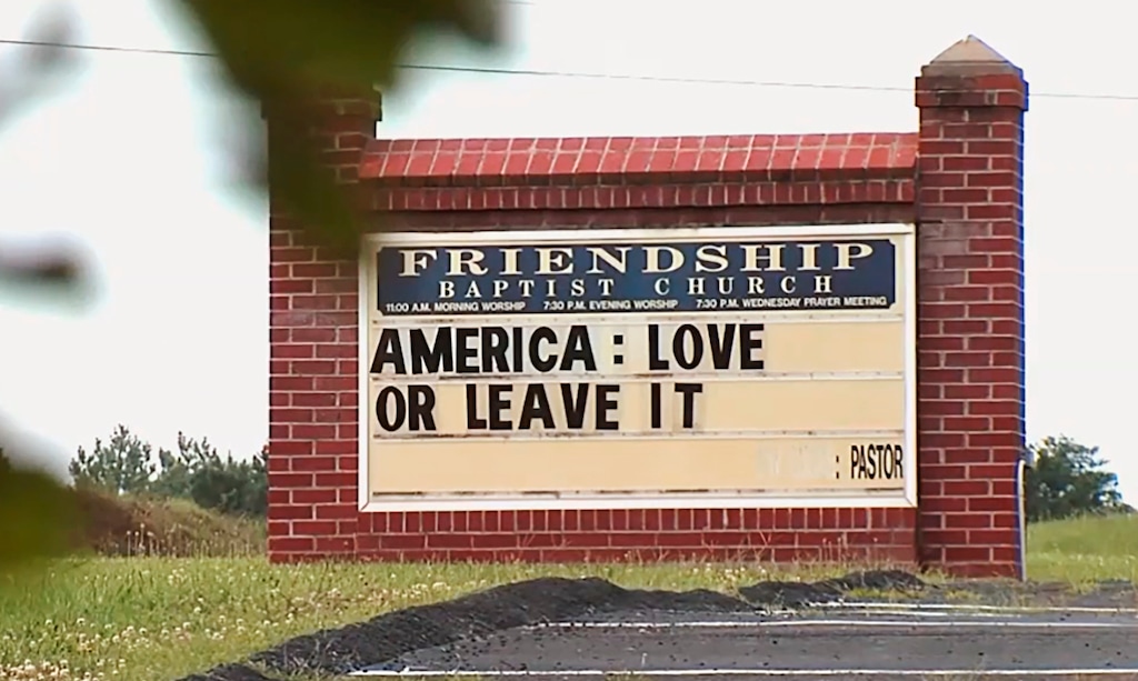 This image taken from video provided by WSET-TV shows a sign "America: Love it or Leave It." posted outside the Friendship Baptist Church in Appomattox, Va., on Tuesday, July 16, 2019. Amid a national furor over President Donald Trump’s tweet urging four Democratic congresswomen to “go back” to their home countries, Pastor E. W. Lucas is gaining attention with the sign at his church (WSET-TV via AP) . MANDATORY CREDIT LYNCHBURG AND ROANOKE OUT