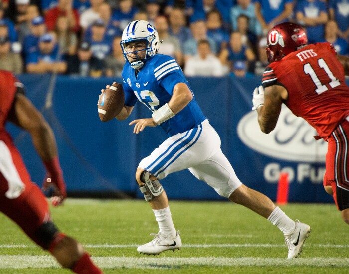 (Rick Egan  |  The Salt Lake Tribune)   Brigham Young Cougars quarterback Tanner Mangum (12) is chased by Utah Utes defensive end Kylie Fitts (11). in football action BYU vs Utah, at Lavell Edwards Stadium in Provo, Saturday, September 9, 2017.