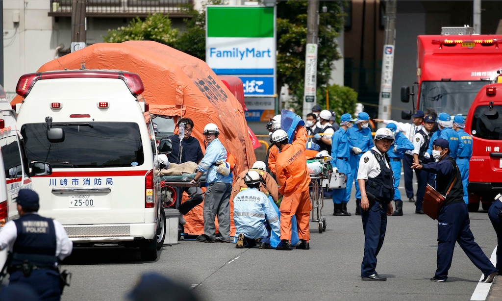 (Kyodo News via AP) Rescuers work at the scene of an attack in Kawasaki, near Tokyo Tuesday, May 28, 2019. A man wielding a knife attacked commuters waiting at a bus stop just outside Tokyo during Tuesday morning's rush hour,  Japanese authorities and media said.