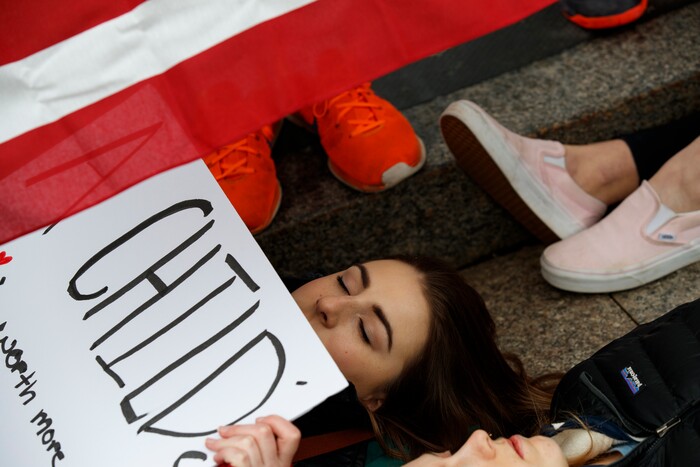 Anna Hurley, 15, of Washington, top, and other demonstrators participate in a "lie-in" during a protest in favor of gun control reform in front of the White House, Monday, Feb. 19, 2018, in Washington. (AP Photo/Evan Vucci)