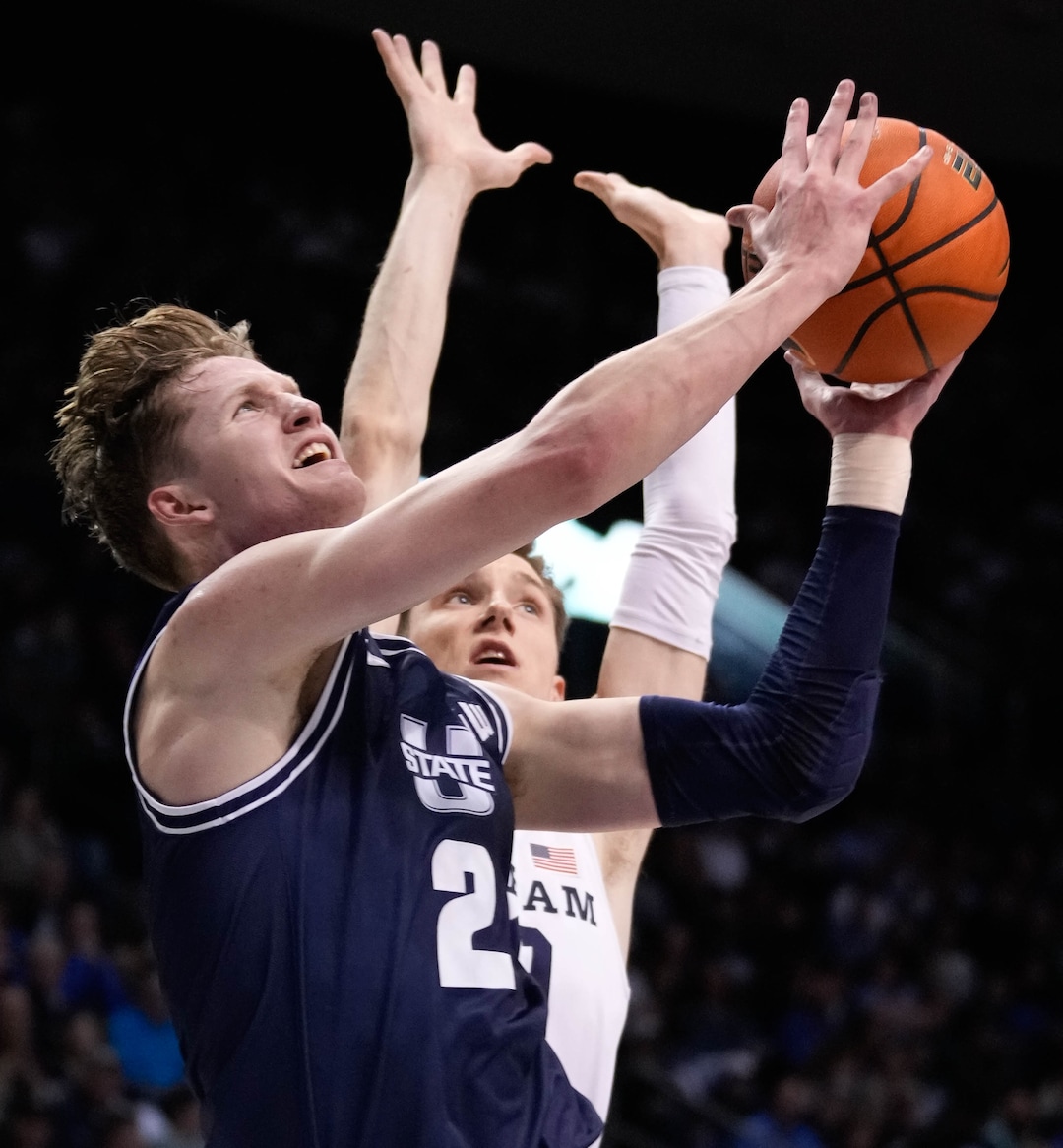 (Francisco Kjolseth | The Salt Lake Tribune) Utah State Aggies guard Sean Bairstow (2) eyes the basket ahead of Brigham Young Cougars guard Spencer Johnson (20) in basketball action between the Brigham Young Cougars and the Utah State Aggies at the Marriott Center in Provo, Wednesday, Dec. 8, 2021.