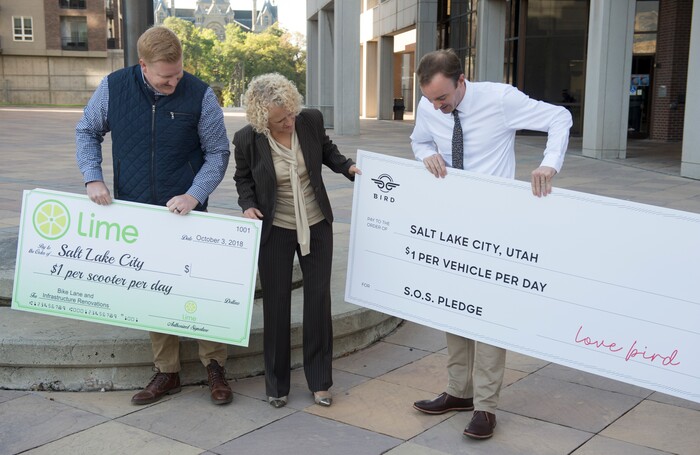 (Rick Egan  |  The Salt Lake Tribune)      Daniel Franklin, operations manager for Lime in Salt Lake City, mayor Jackie Biskupski, and Sam Reed, director of government relations central region for Bird, pose for a photo at a news conference, about the new campaign with e-scooter companies Lime and Bird in an effort to help residents and visitors understand the rules of the sidewalk, Wednesday, Oct. 3, 2018.


