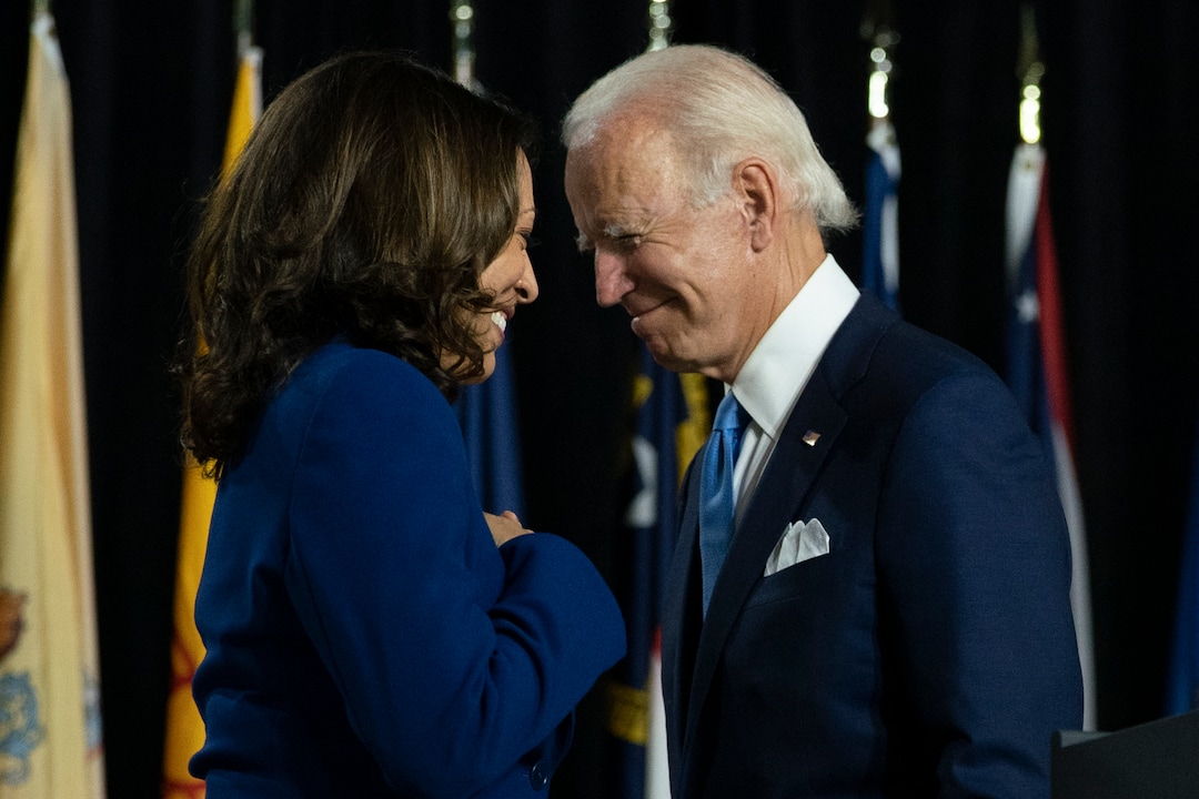 FILE - In this Aug. 12, 2020, file photo, Democratic presidential candidate former Vice President Joe Biden and his running mate Sen. Kamala Harris, D-Calif., pass each other as Harris moves to the podium to speak during a campaign event at Alexis Dupont High School in Wilmington, Del. Harris made history Saturday, Nov. 7,  as the first Black woman elected as vice president of the United States, shattering barriers that have kept men — almost all of them white — entrenched at the highest levels of American politics for more than two centuries. (AP Photo/Carolyn Kaster, File)