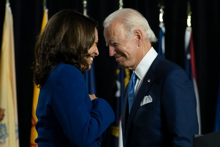 FILE - In this Aug. 12, 2020, file photo, Democratic presidential candidate former Vice President Joe Biden and his running mate Sen. Kamala Harris, D-Calif., pass each other as Harris moves to the podium to speak during a campaign event at Alexis Dupont High School in Wilmington, Del. Harris made history Saturday, Nov. 7,  as the first Black woman elected as vice president of the United States, shattering barriers that have kept men — almost all of them white — entrenched at the highest levels of American politics for more than two centuries. (AP Photo/Carolyn Kaster, File)