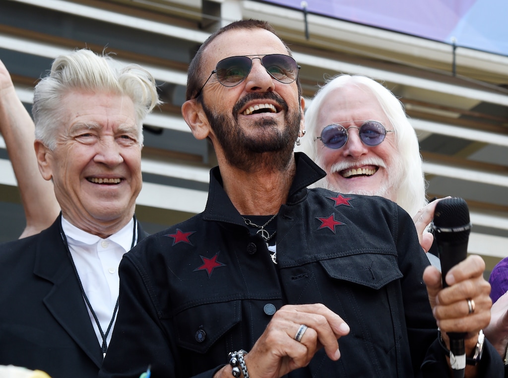 FILE - In this Friday, July 7, 2017 file photo, Ringo Starr, center, is joined by guests including filmmaker David Lynch, left, and musician Edgar Winter, second from right, during a 77th birthday celebration for Starr outside Capitol Records, in Los Angeles. A Beatle and a Bee Gee have topped the list of celebrated people designated to receive knighthoods and other awards in the New Year’s Honors List. They are joined by a noted children’s author celebrated for “War Horse,” a politician who fought in vain to keep Britain in the European Union, and many others, including renowned researchers, volunteers and actors.  (Photo by Chris Pizzello/Invision/AP, File)
