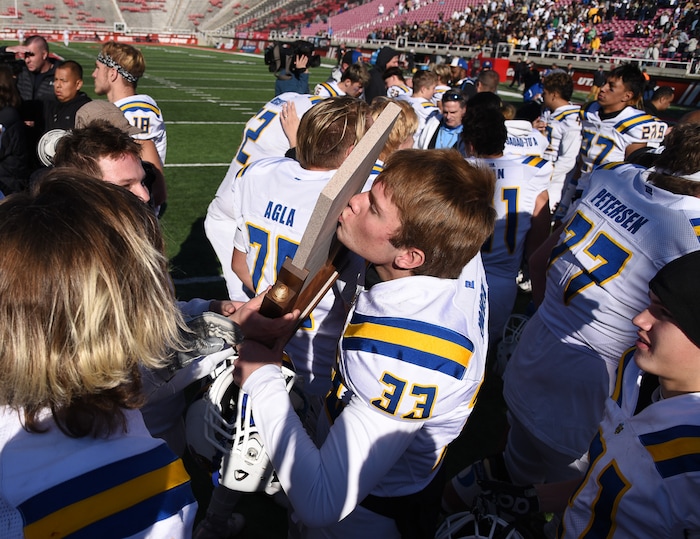 (Francisco Kjolseth  |  The Salt Lake Tribune)  Orem's Sam Yokota kisses the trophy as the team celebrates after winning the 4A high school championship game against Dixie at Rice-Eccles Stadium in Salt Lake City, Friday, Nov. 16, 2018. 